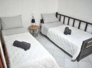 a bedroom with two beds and a table with a lamp at Raeti Cretan Guesthouse in Moírai