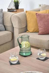 a glass pitcher and two glasses on a coffee table at Raeti Cretan Guesthouse in Moírai