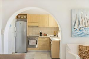 a kitchen with a refrigerator and an archway at Ampelas - 3BR Cycladic House - White Heaven Apt4 in Ambelas
