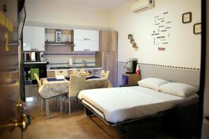 a room with a bed and a table and a kitchen at Casa Alma in Naples