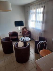 uma sala de estar com cadeiras, uma mesa e uma televisão em DYNAMIQUE ET SPLENDIDE em Bourgoin-Jallieu