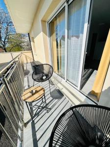 uma varanda com uma mesa e cadeiras numa casa em Paname ou Rouen ? em Freneuse