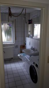 a white bathroom with a sink and a toilet at Wohnung Emilia in Mörfelden-Walldorf