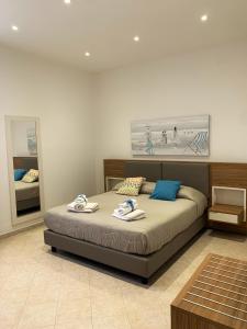 a bedroom with a bed with towels on it at Talos Apartments in San Vito lo Capo