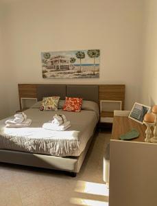 a bedroom with a bed with towels on it at Talos Apartments in San Vito lo Capo