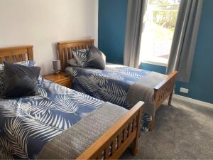a room with two beds and a window at Sunnybank, Kensaleyre in Portree