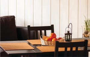 a table with a basket of fruit and a candle at Two-Bedroom Holiday Home In Middelhagen in Alt Reddevitz