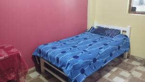 een slaapkamer met een blauw en wit dekbed op een bed bij DEPA OSAMA in Ayacucho