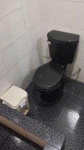 een badkamer met een zwart toilet in een kamer bij DEPA OSAMA in Ayacucho