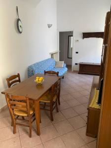 ein Wohnzimmer mit einem Tisch und einem blauen Sofa in der Unterkunft casa 102 in Finale Ligure