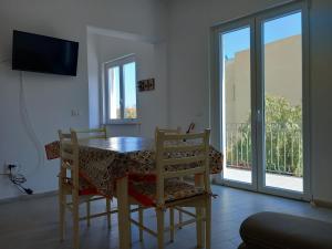 a dining room with a table and chairs and a balcony at Da Raff in Lacco Ameno