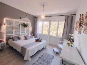 a bedroom with a large white bed and windows at Villa Neptuno in Tossa de Mar +30 photos