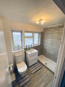 La salle de bains est pourvue de toilettes, d'un lavabo et d'une douche. dans l'établissement Single Room, Shared House, à Bristol