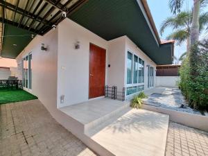 a house with a red door and a patio at Midas Pool Villa in Jomtien Beach