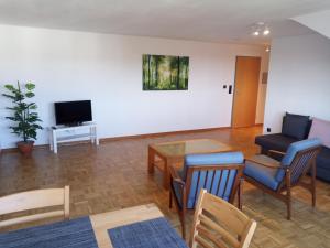 a living room with a table and chairs and a television at ZumLeroy in Völklingen