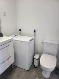 a white bathroom with a toilet and a sink at bien situé entre mer et montage in Santa-Maria-di-Lota