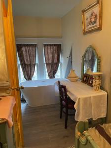 a room with a bath tub and a table with a chair at Henderson Castle Inn in Kalamazoo