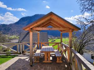 a wooden pavilion with a picnic table on a patio at Apartmaji Mojca in Bohinj