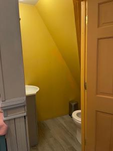bagno giallo con servizi igienici e lavandino di Henderson Castle Inn a Kalamazoo