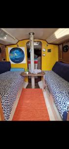 una habitación con 2 camas y una mesa en una furgoneta en El barquito de arrecife, en Arrecife