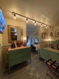a bedroom with green dressers and a bed and a table at Henderson Castle Inn in Kalamazoo