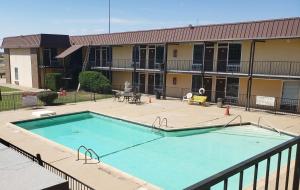 a large swimming pool in front of a building at West Texas Inn & Suites Midland in Midland