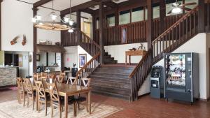 a dining room with a table and a staircase at West Texas Inn & Suites Midland in Midland