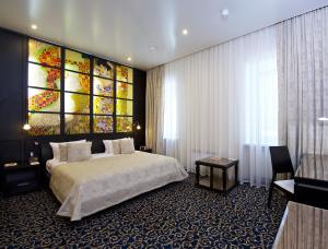 a hotel room with a large bed and a large window at Metelitsa Hotel in Krasnoyarsk