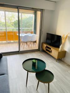 een woonkamer met een tafel en een televisie bij Studio Frejus plage in Fréjus