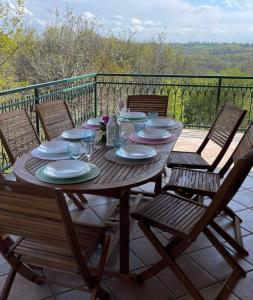 uma mesa de madeira com pratos e copos num pátio em Villa Martini dei Rossi em Sanfrè