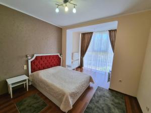 a bedroom with a bed and a large window at Helen Hotel in Mykolaiv