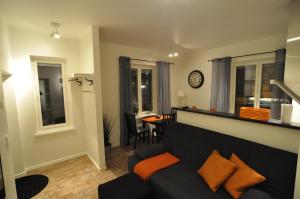 a living room with a couch and a clock on the wall at Townhouse Apartments in Mariehamn +8 photos