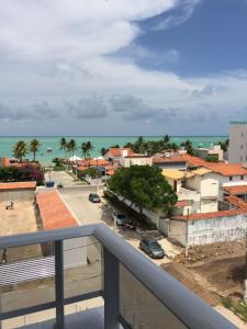 a balcony with a view of a city and the ocean at Lindo apartamento de férias à 100m do mar! in Cabedelo