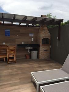 a patio with a brick oven and a table at Lindo apartamento de férias à 100m do mar! in Cabedelo