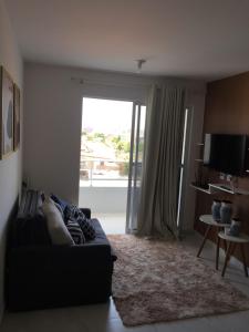 uma sala de estar com um sofá e uma grande janela em Lindo apartamento de férias à 100m do mar! em Cabedelo