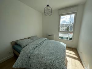a bedroom with a bed and a window at Appartement Caen in Caen