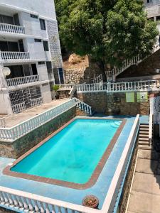 a swimming pool in front of a building at Sobre Costera, 1min La Quebrada, 3m playas/yates in Acapulco