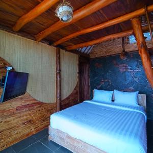 a bedroom with a bed and a flat screen tv at Ama Awa Resort in Kemadang
