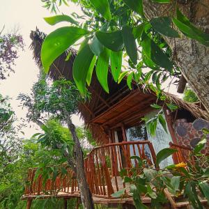 a tree house with a deck in the woods at Ama Awa Resort in Kemadang