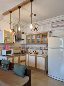 a kitchen with a white refrigerator and a couch at Appartement vue mer in Mahdia