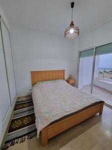 sypialnia z łóżkiem i dużym oknem w obiekcie Appartement vue mer w mieście Mahdia