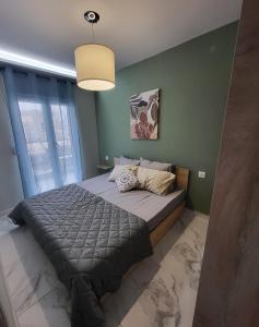 um quarto com uma cama grande num quarto com paredes verdes em MT APARTMENTS em Néoi Epivátai