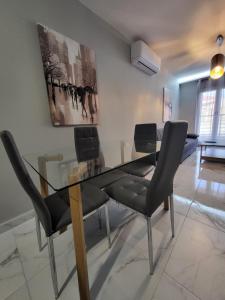 a dining room with a glass table and chairs at MT APARTMENTS in Neoi Epivates