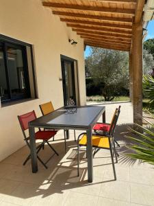 einen Tisch und Stühle auf einer Terrasse in der Unterkunft "Les cigales" aux portes de la Provence in Bollène