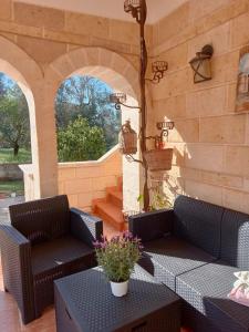 a patio with two chairs and a table and two windows at Villa Gemma in San Vito dei Normanni