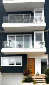 a black and white building with a balcony at ONE100 apartments in Marsaxlokk