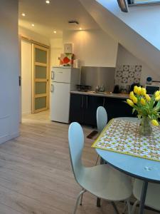une cuisine avec une table et un vase de fleurs. dans l'établissement Magnifique logement, confortable et paisible., à Saint-Marcel