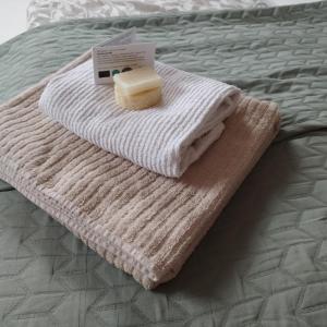 - une serviette brune et blanche sur un lit dans l'établissement Seenswert - Vegane Pension und Ferienwohnungen am Ammersee, à Pähl