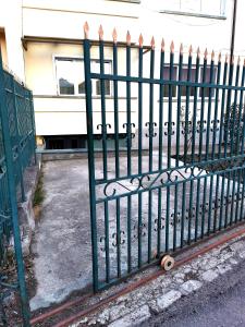 a green metal fence next to a building at Uranus Studio in Piatra Neamţ