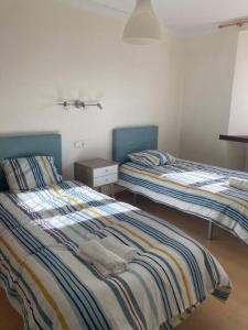 a bedroom with two beds and a night stand at El encanto de un pueblo 